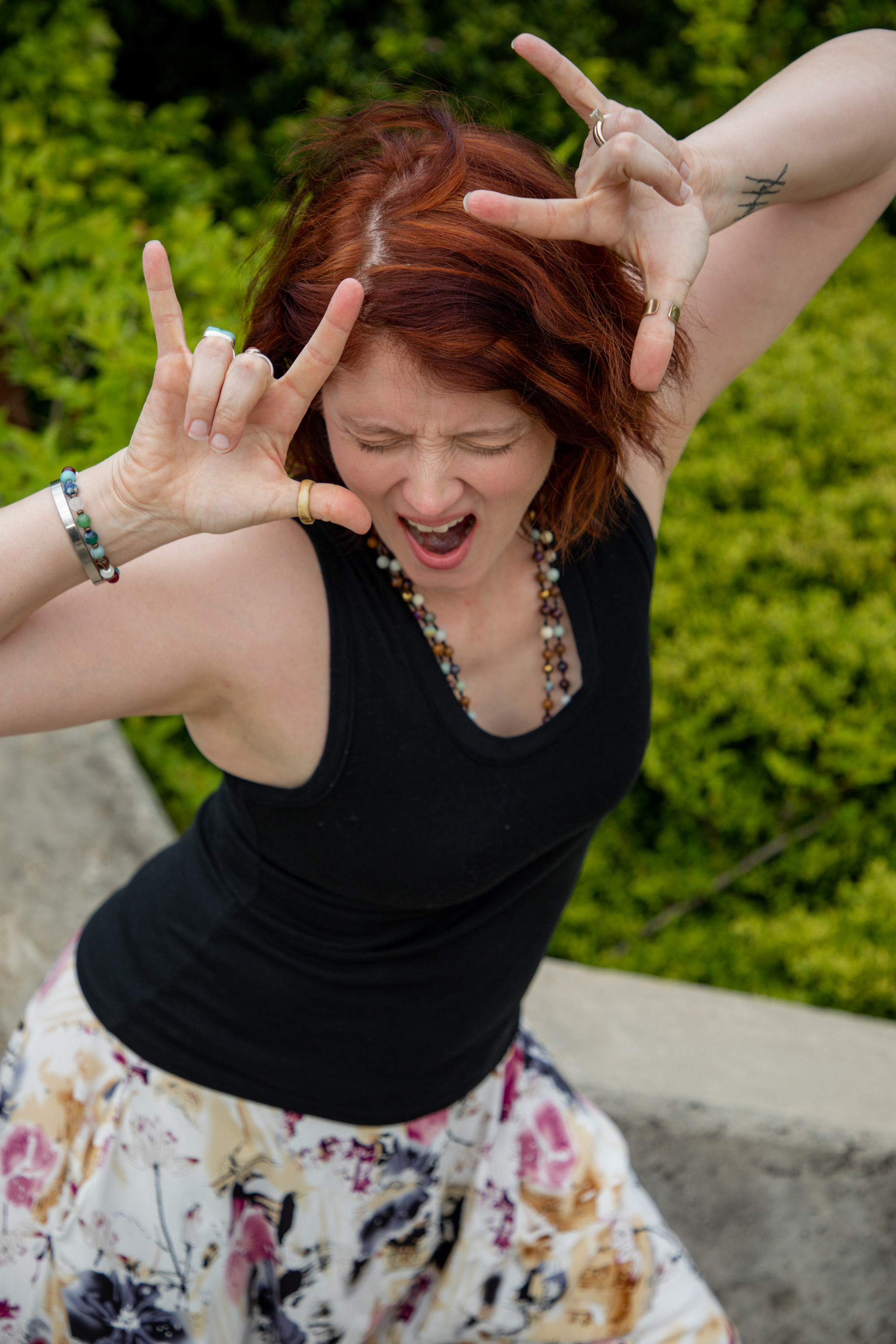 Carli Webb outdoors, arms raised, mid-laugh